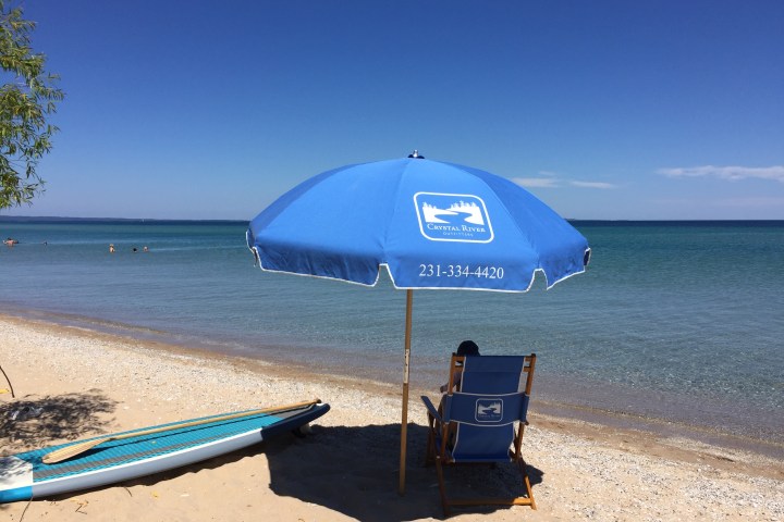 a blue umbrella sitting on top of a sandy beach