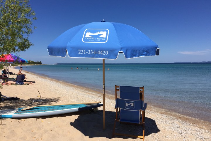 a group of lawn chairs sitting on top of a sandy beach