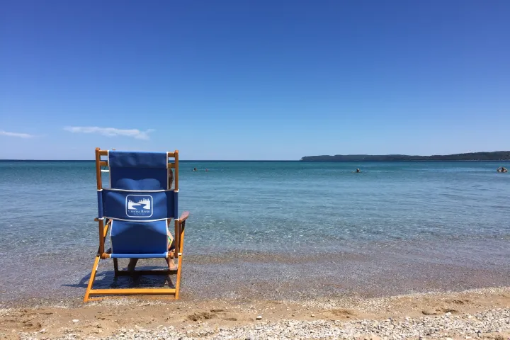 a person sitting on top of a sandy beach next to the ocean