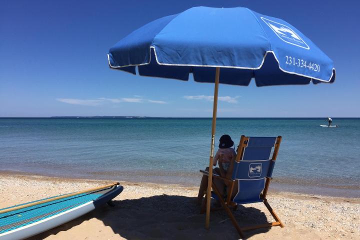 a couple of lawn chairs sitting on top of a beach