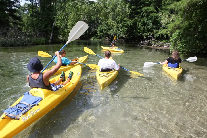 a group of people riding on the back of a boat in the water