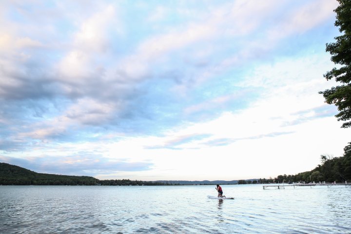 a man standing next to a body of water