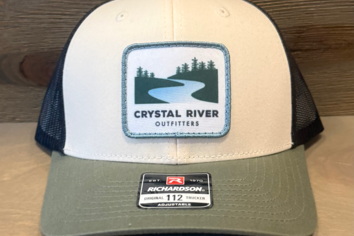 Trucker hat with 'Crystal River Outfitters' logo on a beige front and green brim.