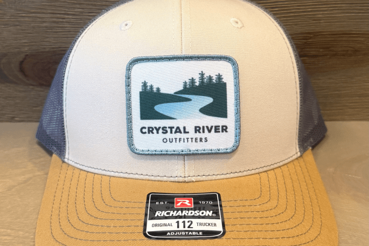 Beige and brown trucker hat with 'Crystal River Outfitters' logo on front.
