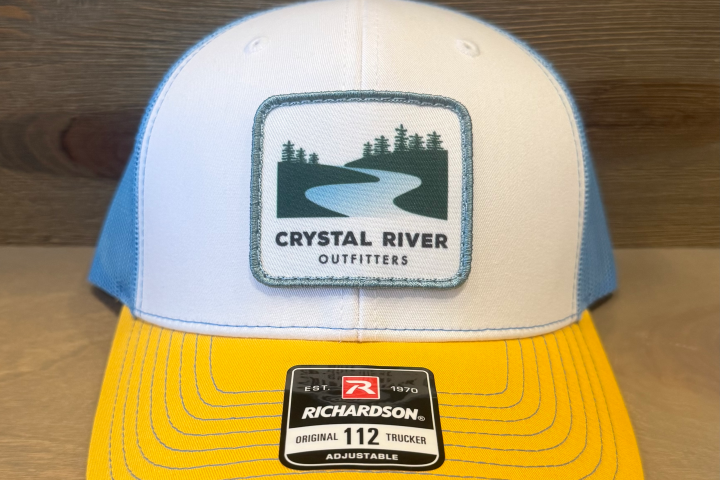 Trucker cap with 'Crystal River Outfitters' logo, blue sides, white front, and yellow brim with a sticker.