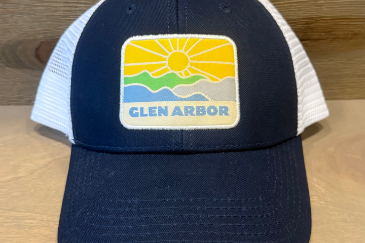 Trucker hat with 'Glen Arbor' and sun design, navy front, white mesh back.