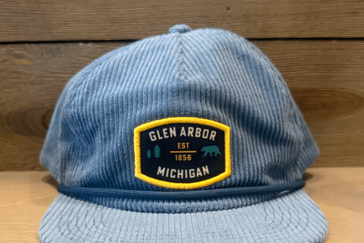 Blue corduroy cap with 'Glen Arbor Michigan Est 1856' patch on the front