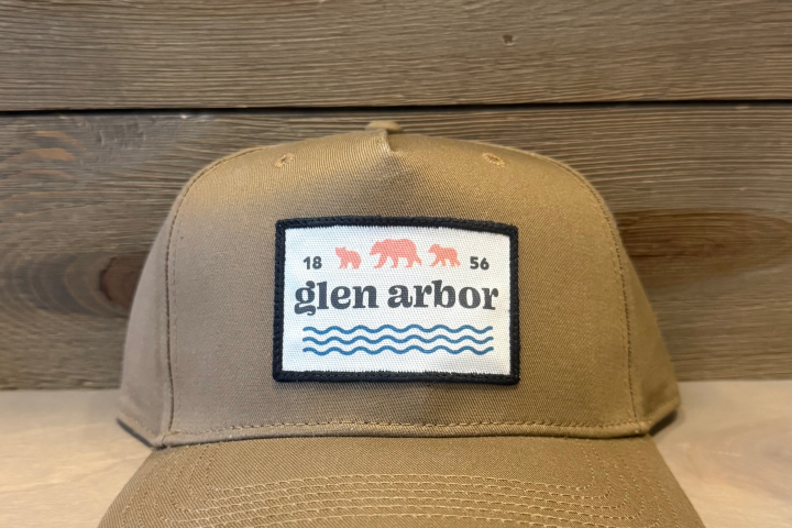 Brown cap with 'glen arbor' patch, bears, and waves.